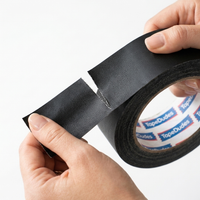 Person easily tearing a strip of black matte gaffer tape by tapedudes